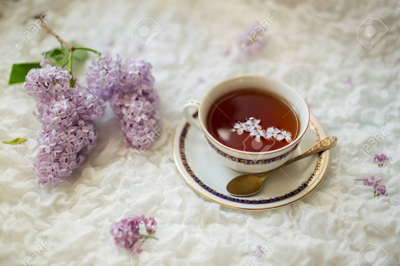 Cup Of Black Aromatic Tea On With Lilac Petals And Bunch Of Lilac Flowers On White Delicate Textile Background Stock Photo Picture And Royalty Free Image Image