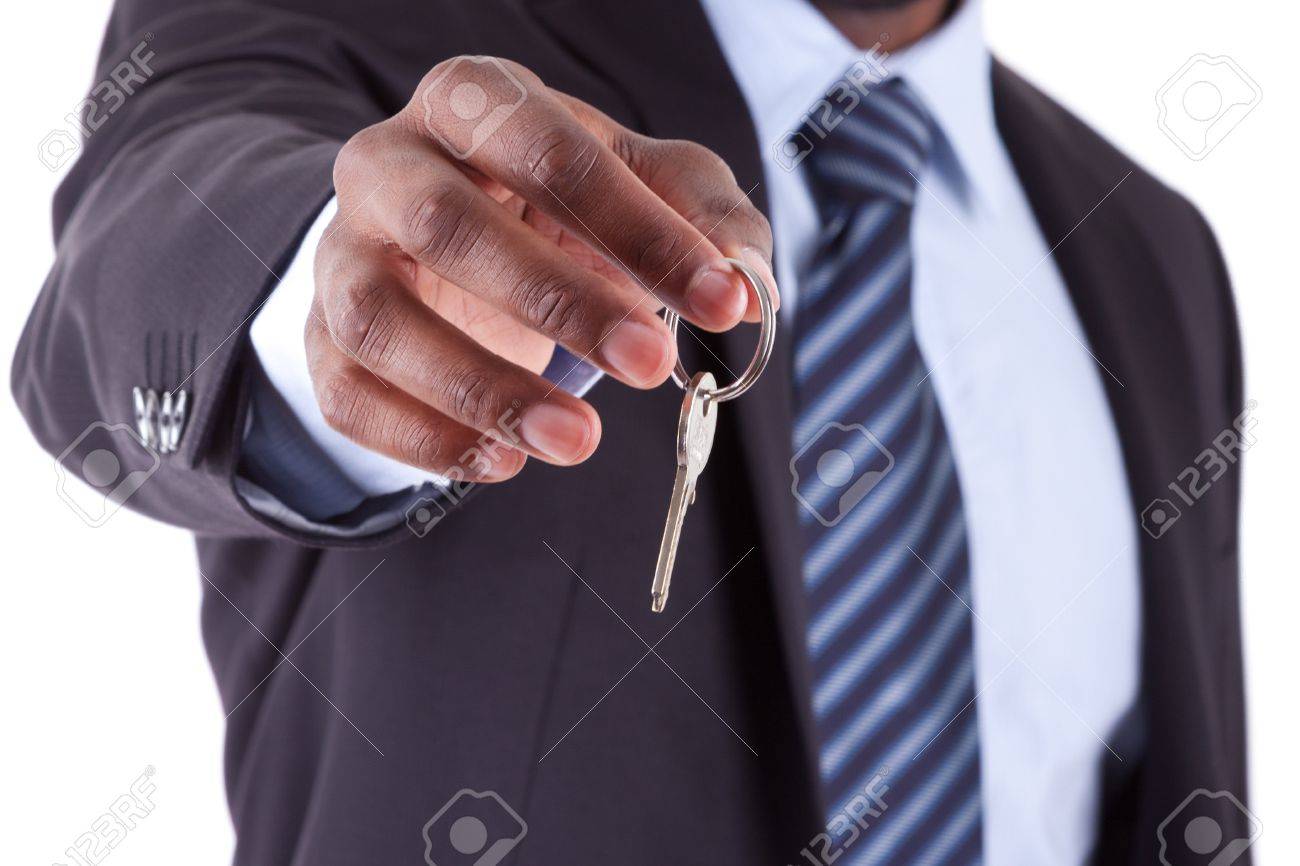 Young African American businessman holding a house key, isolated on white background - 16589209 Young African American businessman holding a house key, isolated on white background - 16589209