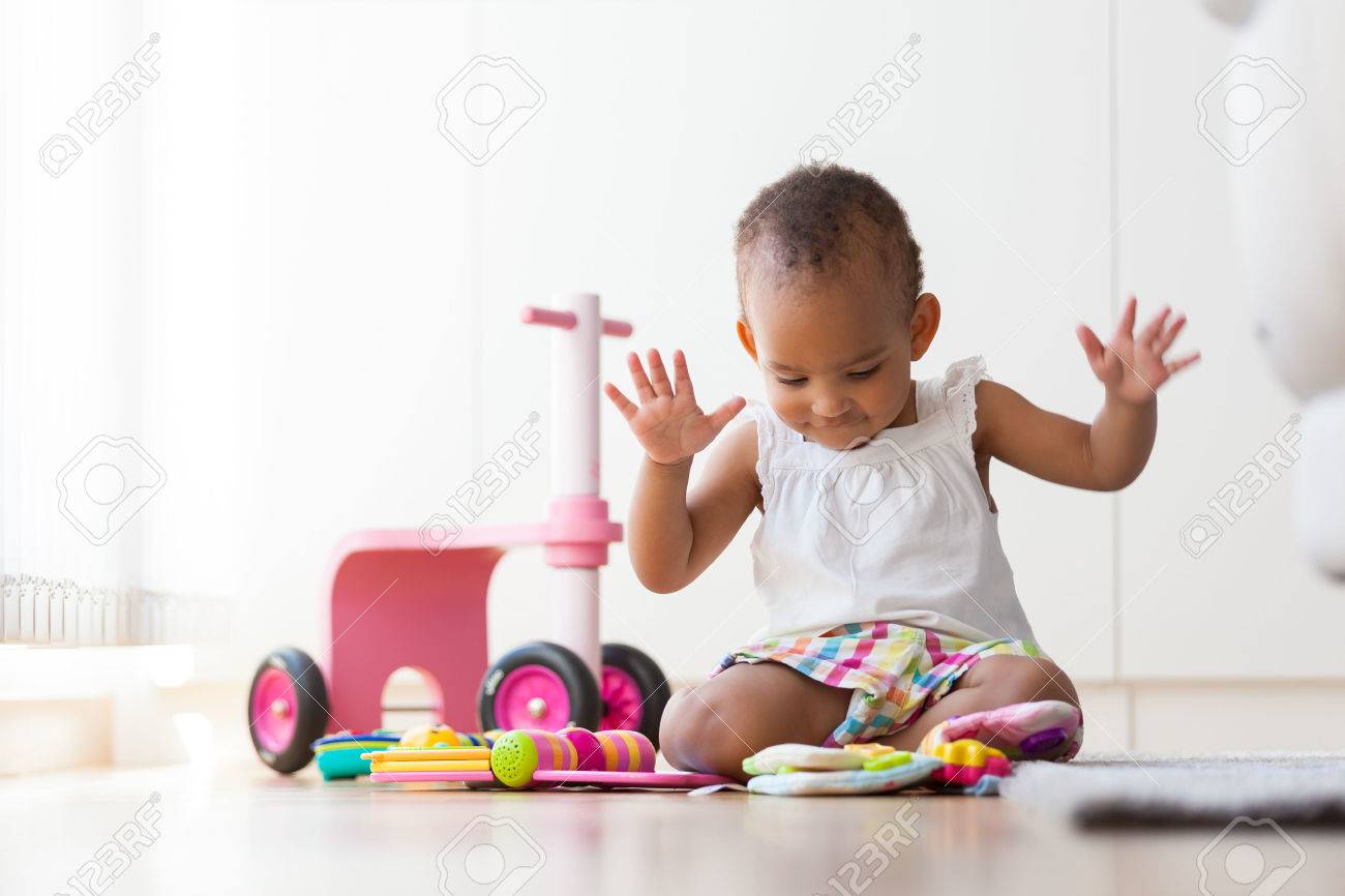 Portrait of little African American little girl sitting on the floor and playing - Black people - 43224720 Portrait of little African American little girl sitting on the floor and playing - Black people - 43224720