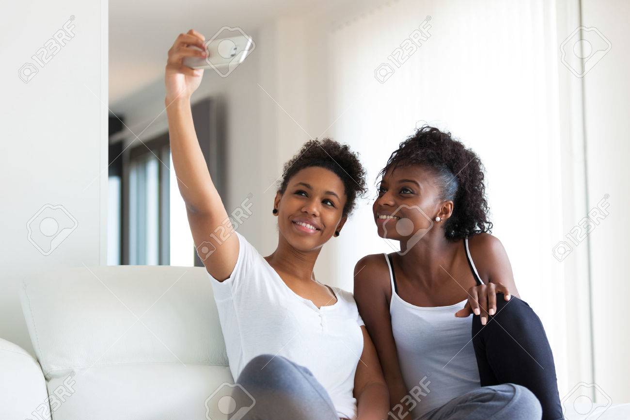 African American teenage girls taking a selfie picture with a smartphone - 46714035 African American teenage girls taking a selfie picture with a smartphone - 46714035
