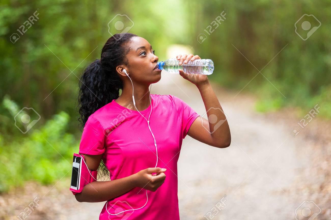African american woman jogger drinking water - Fitness, people and healthy lifestyle - 53975440 African american woman jogger drinking water - Fitness, people and healthy lifestyle - 53975440