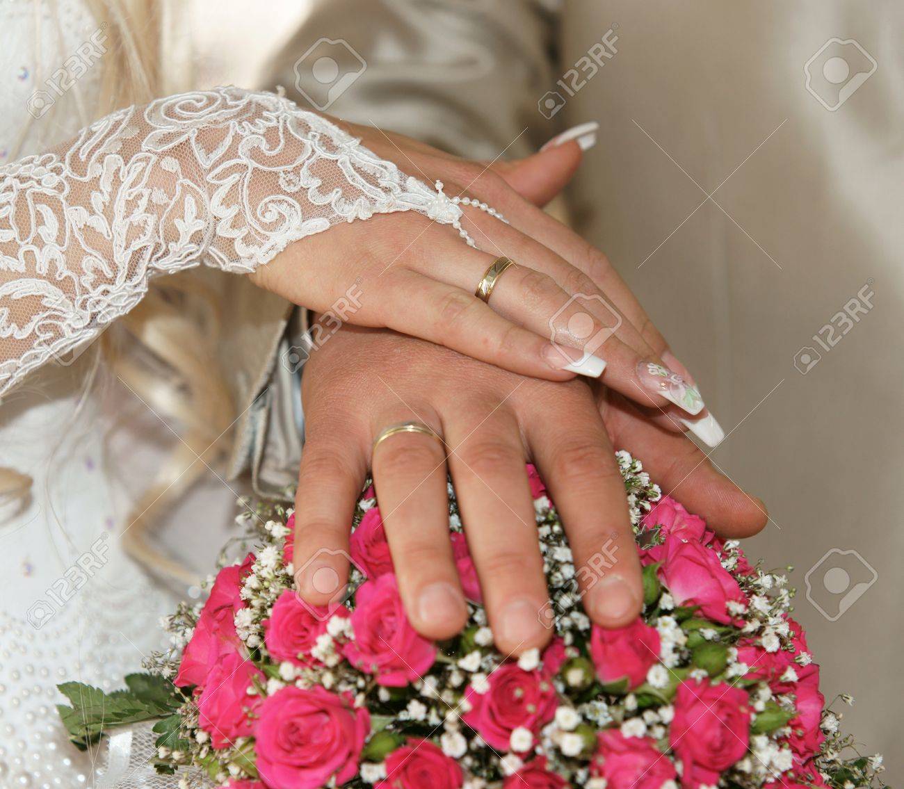 De Recién Casados Las Manos Con Anillos De Oro En Un Bonito Ramo De La Boda Fotos, Retratos, Imágenes Y Fotografía De Archivo Libres De Derecho. Image