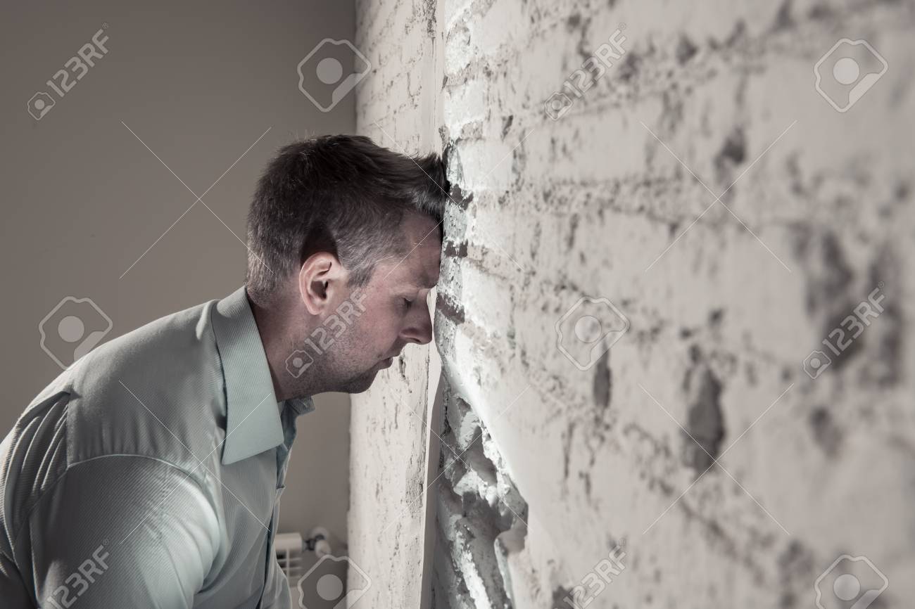 Depressed Man Leaning Up On A White Wall In Dark Room At Home Stock Photo Picture And Royalty Free Image Image 109694824