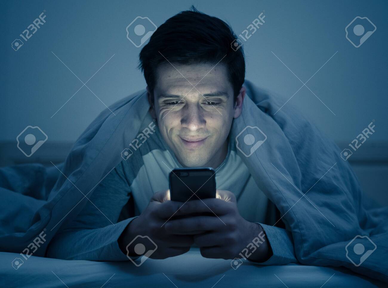 https://previews.123rf.com/images/samwordley/samwordley1904/samwordley190400590/121213030-young-mobile-phone-addict-man-awake-at-night-in-bed-using-smartphone-for-chatting-flirting-and.jpg