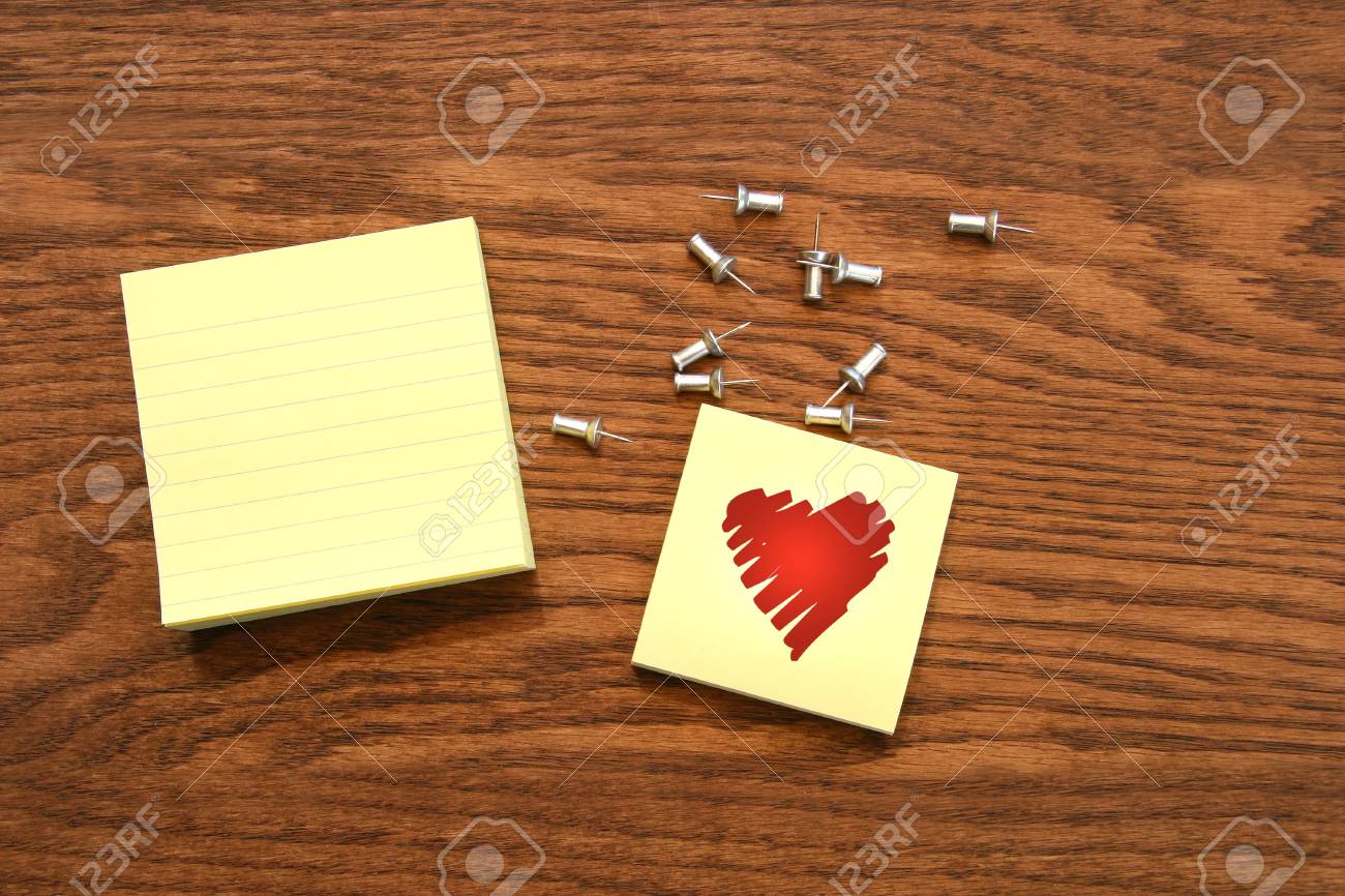 yellow sticky note pads with silver push pins on oak wood stock