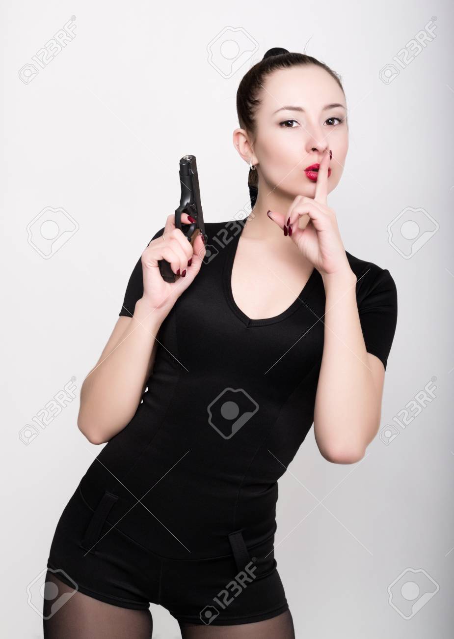 ハイヒール 持株銃にレースのランジェリーで脚の長いスリムな美しいセクシーな女の子は ポーズ彼の唇に人差し指を発生します の写真素材 画像素材 Image