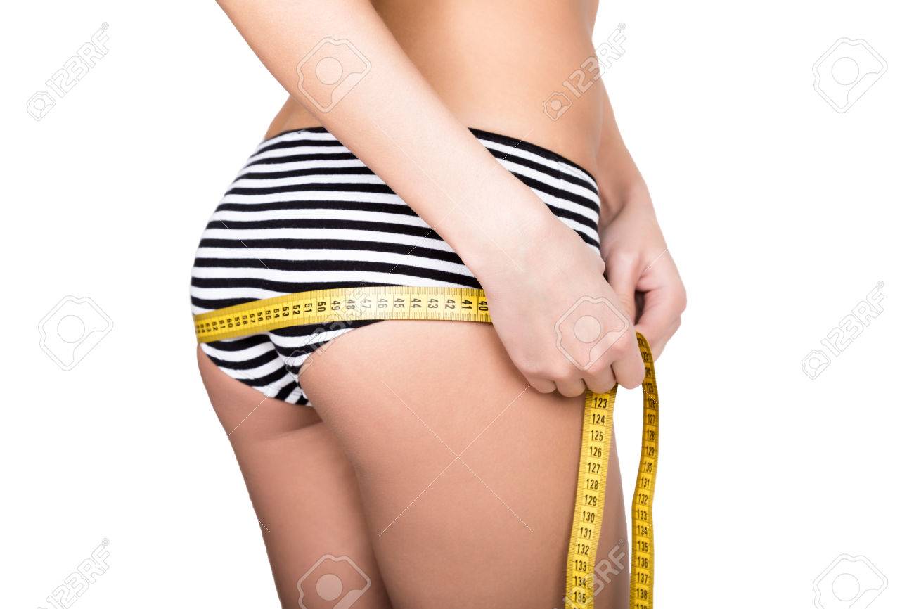 Stock Photo Young Fit Woman Wearing Striped Panties Holding A Measuring Tape With Her Hands On Thigh And Ass Isolated On A White Background Stock Photo Young Fit Woman Wearing Striped Panties Holding A Measuring Tape With Her Hands On Thigh And Ass Isolated On A White Background