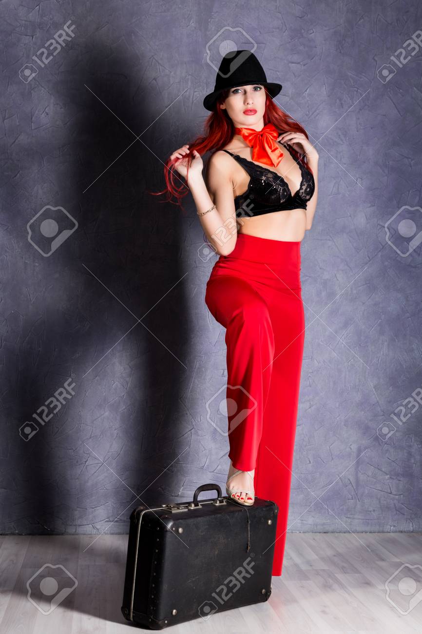 赤いズボンと巨乳ホールド レトロなスーツケースと黒い帽子の女の写真素材・画像素材 Image 78772482