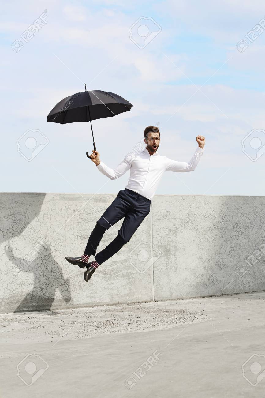 man with umbrella jumping