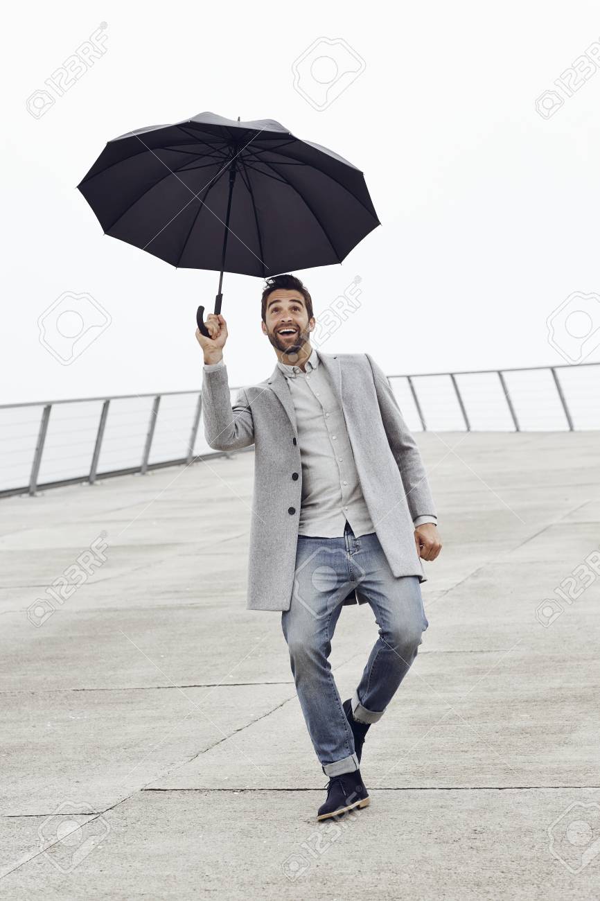 excited guy with umbrella looking up stock photo picture and