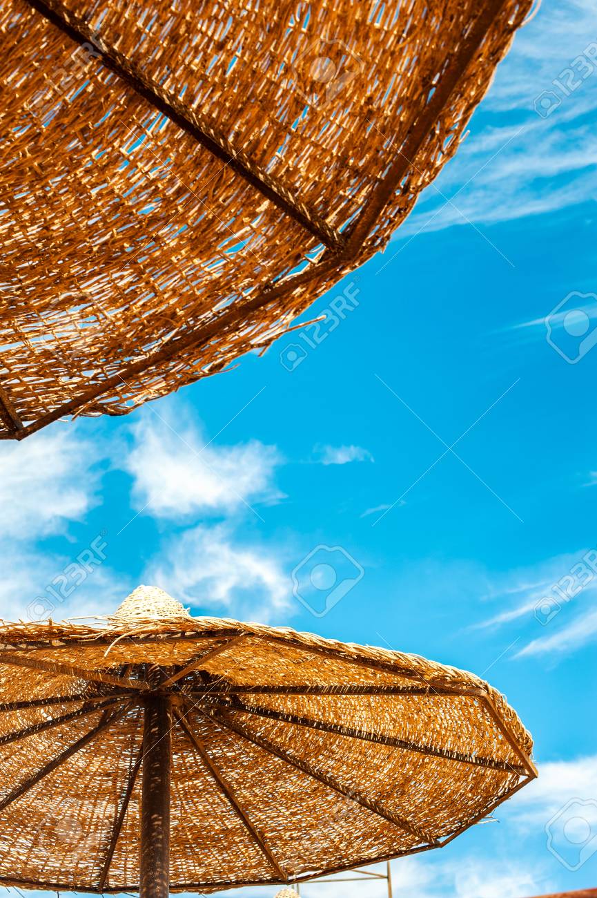 Wattled Straw Beach Umbrella On Blue Cloudy Sky Background Outdoors