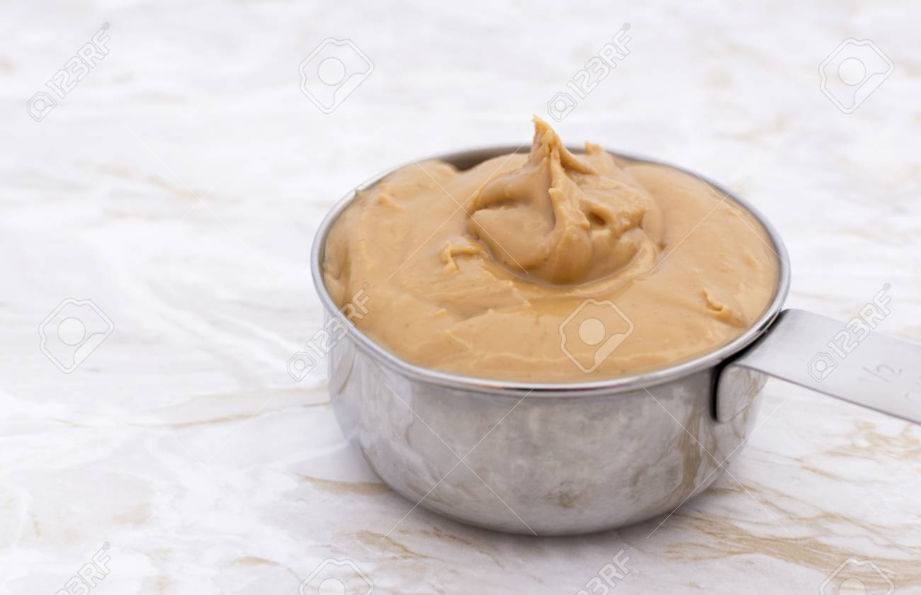 Smooth Peanut Butter In A Metal Measuring Cup On A Kitchen Worktop Stock Photo Picture And Royalty Free Image Image 50337657