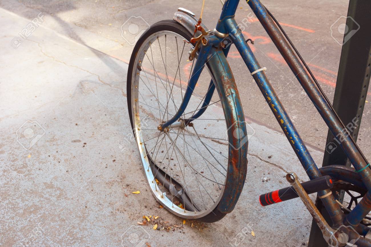 捨てられた錆びた自転車のルースタイヤが付いている壊れた前輪は 金属の棒に固定した の写真素材 画像素材 Image