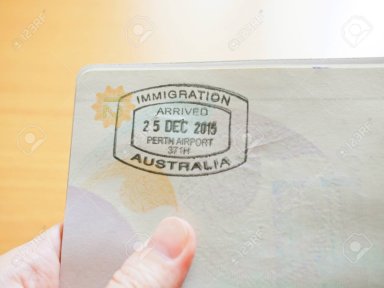 Hand Holding Passport With Australian Immigration Stamp For Entering The Country Stock Photo, Picture And Royalty Free Image 100614909.