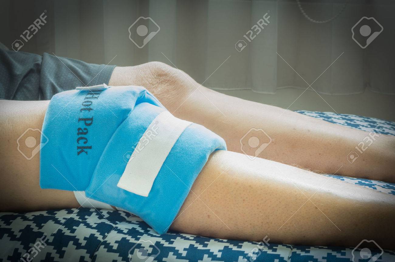 Asian old man use hot and cold gel to wrap his knee to relief knee injuries.Selective focus. - 56191513 Asian old man use hot and cold gel to wrap his knee to relief knee injuries.Selective focus. - 56191513