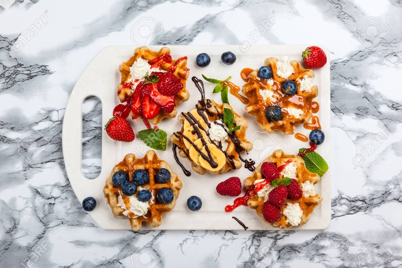 Kostliche Belgische Waffeln Mit Beeren Fruchten Schlagsahne Und Verschiedenen Sussen Topping Auf Weissem Marmor Draufsicht Lizenzfreie Fotos Bilder Und Stock Fotografie Image 79225381