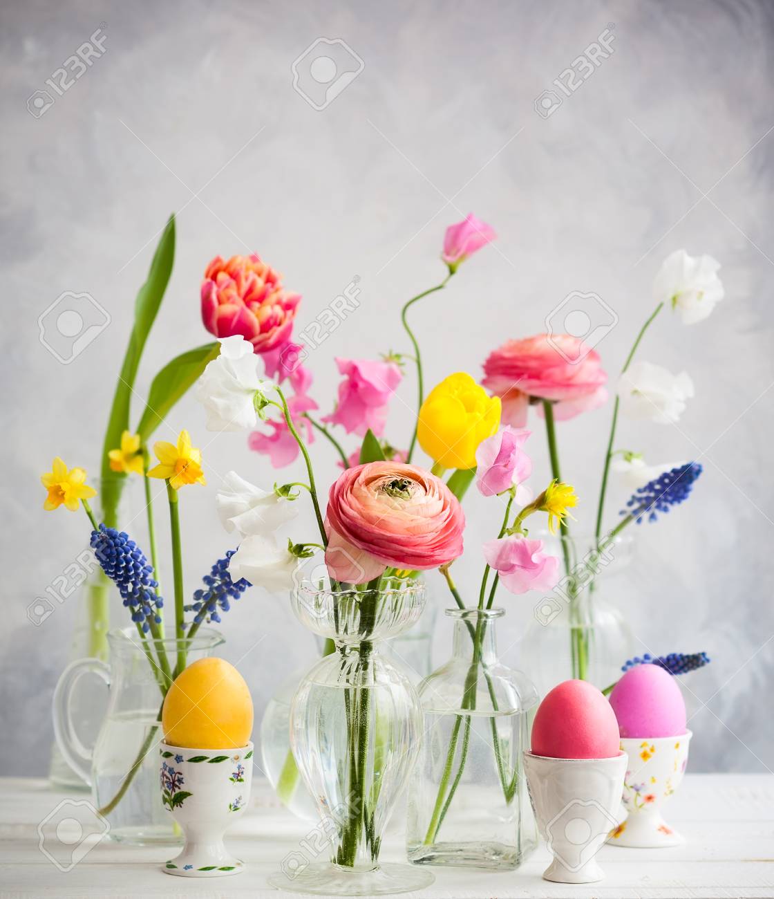 Belles Fleurs Bouquets Dans Des Vases En Verre Sur La Table De Fête De Pâques Oeufs De Pâques Colorés Dans Des Coquetiers