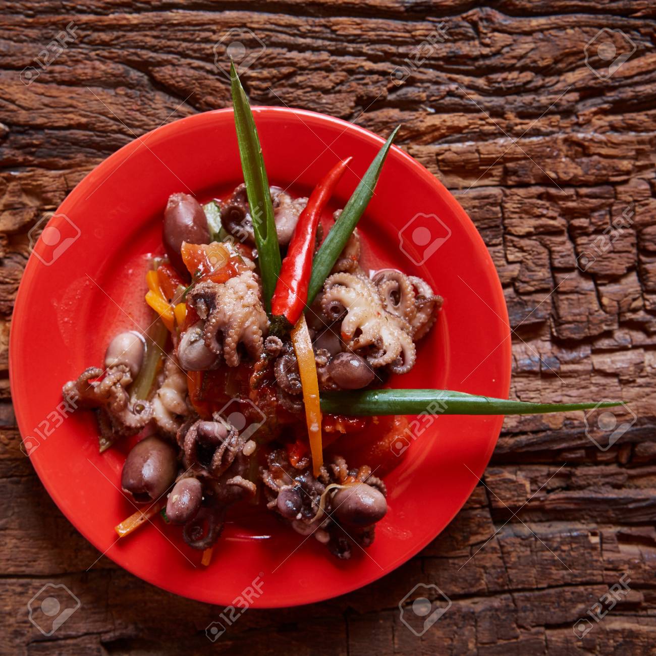 Poulpes Bebe Dans Un Plat Rouge Avec Copie Espace Sur Fond De Bois Banque D Images Et Photos Libres De Droits Image