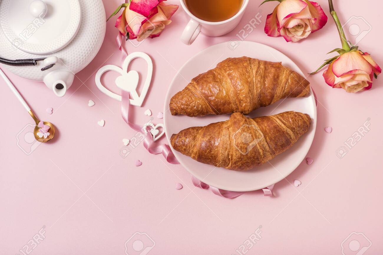 Romantic breakfast with croissants, roses and tea on pink background, Valentine's day celebration, top view - 139572600 Romantic breakfast with croissants, roses and tea on pink background, Valentine's day celebration, top view - 139572600