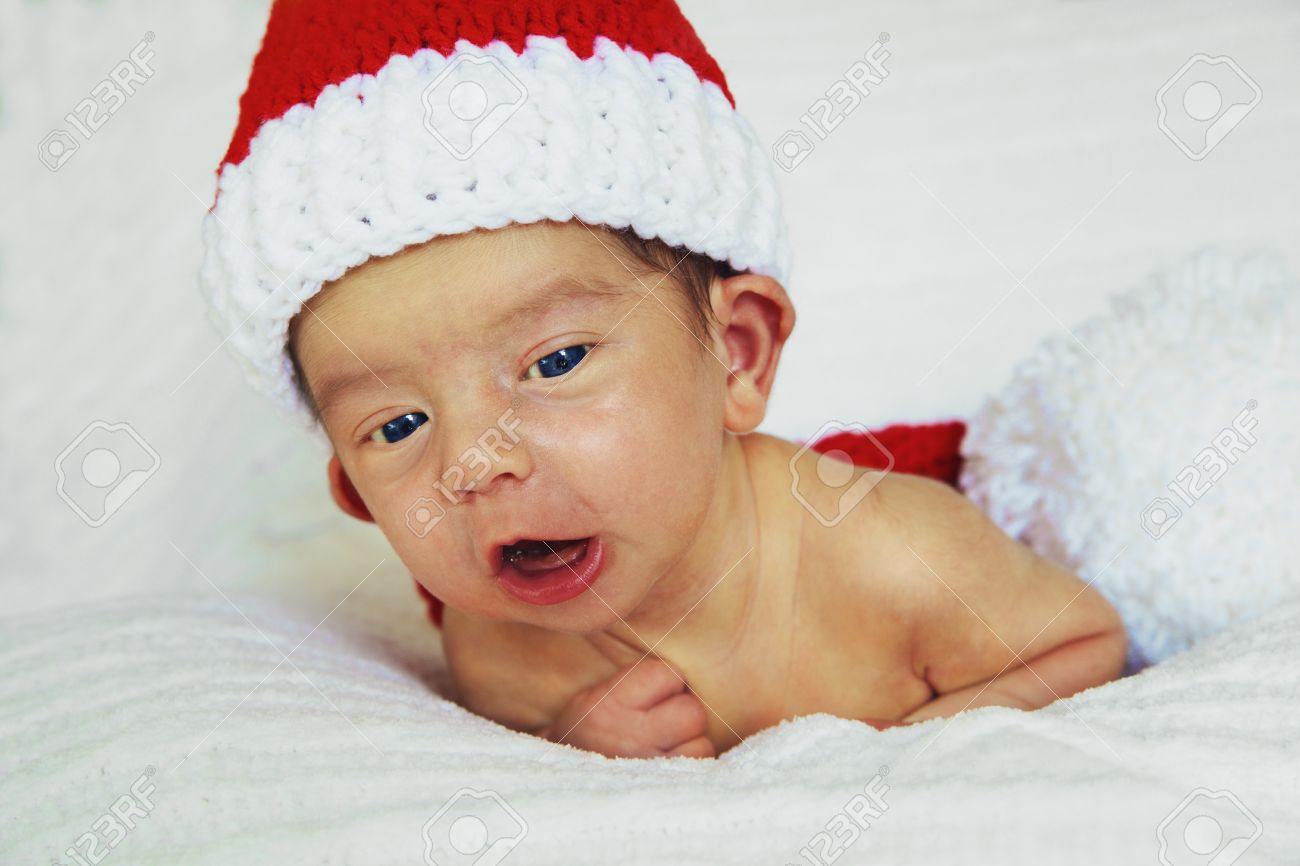 Cute New Born Baby Boy In Bed With Santa Claus Hat Stock Photo