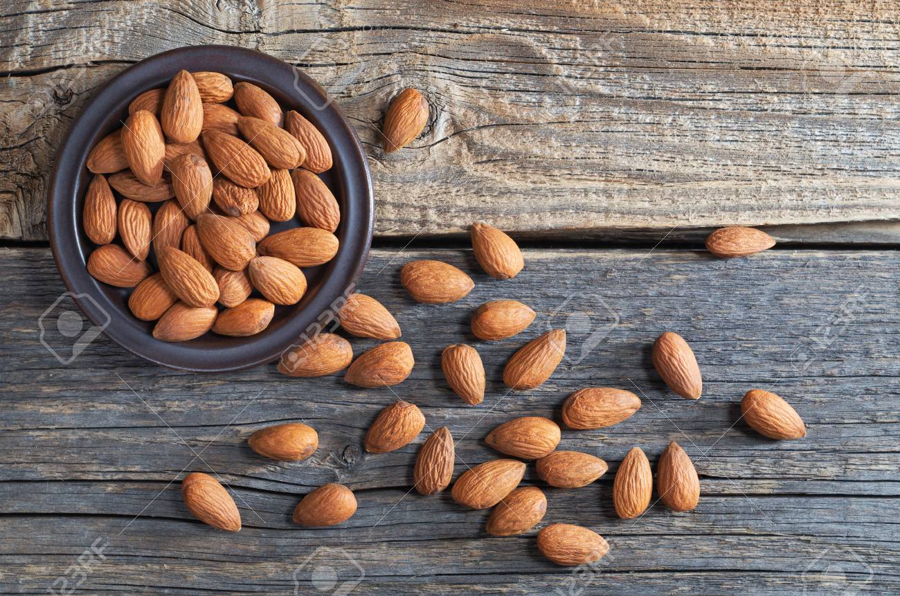 Orzechy Migdałowe W Talerzu I Rozrzucone Na Starym Drewnianym ...