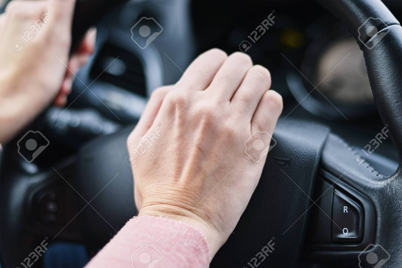 Driver hand pressed horn button on car wheel - 136692182 Driver hand pressed horn button on car wheel - 136692182