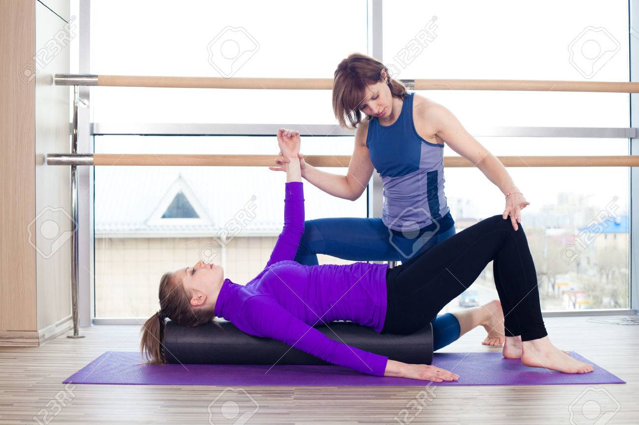 Aerobics Pilates personal trainer helping women group in a gym class - 40069278 Aerobics Pilates personal trainer helping women group in a gym class - 40069278