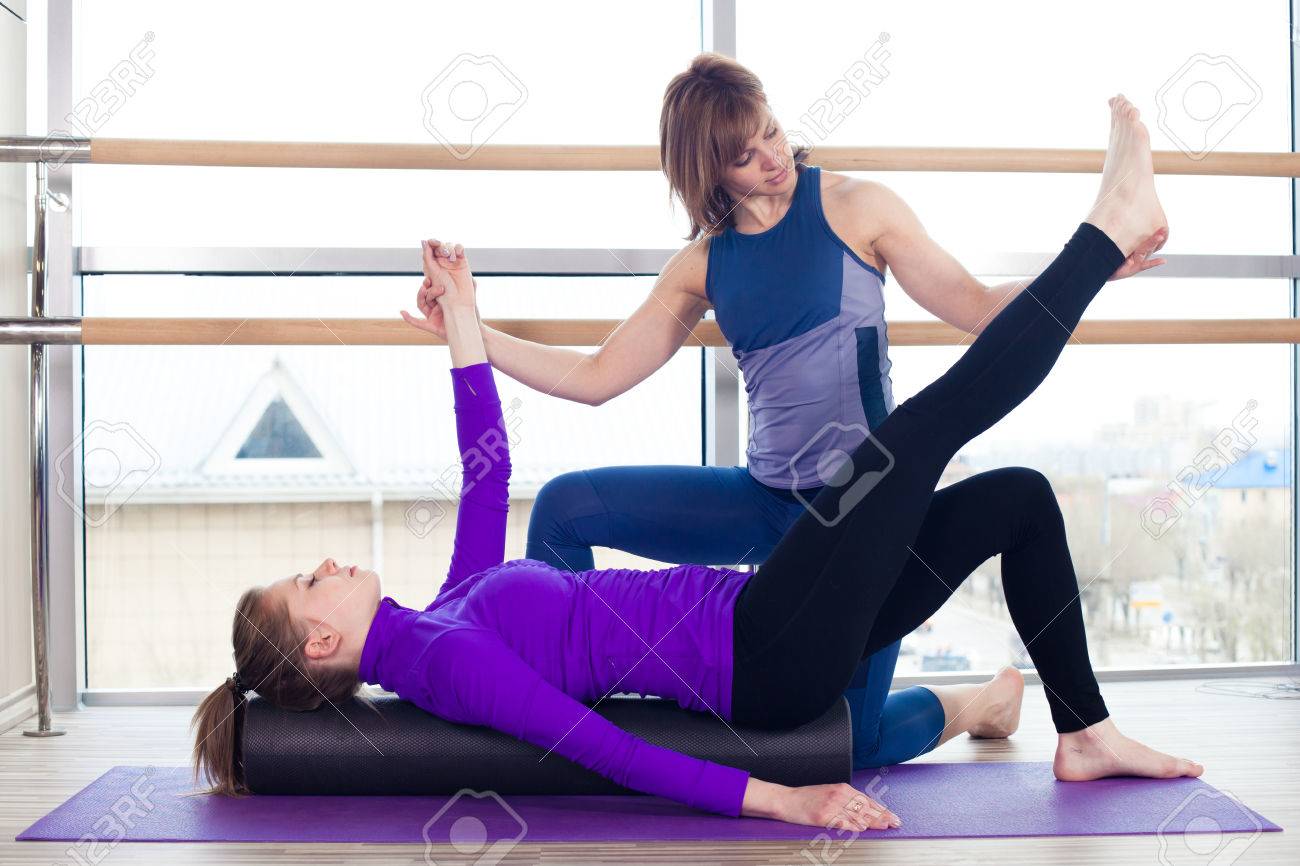 Aerobics Pilates personal trainer helping women group in a gym class - 40069279 Aerobics Pilates personal trainer helping women group in a gym class - 40069279