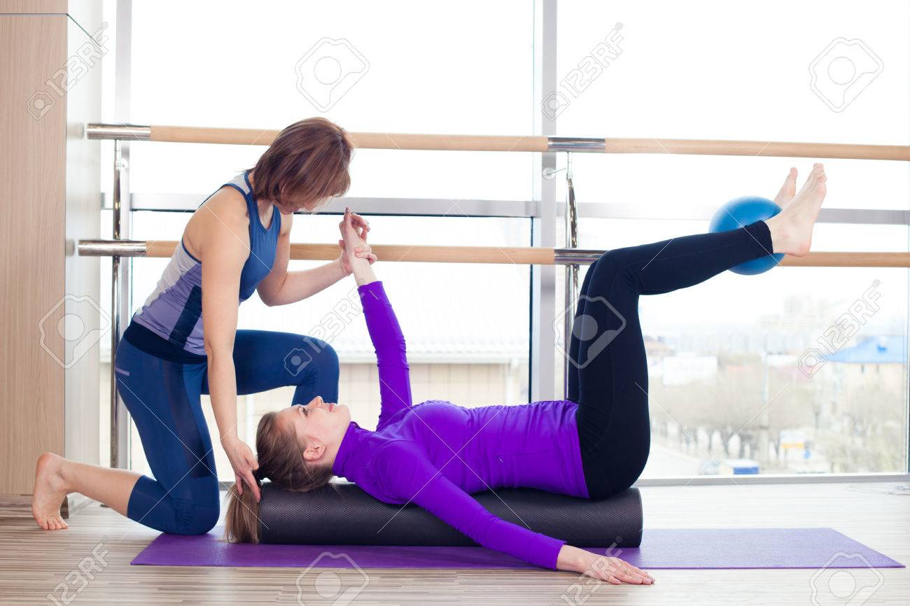 Aerobics Pilates personal trainer helping women group in a gym class - 40069288 Aerobics Pilates personal trainer helping women group in a gym class - 40069288