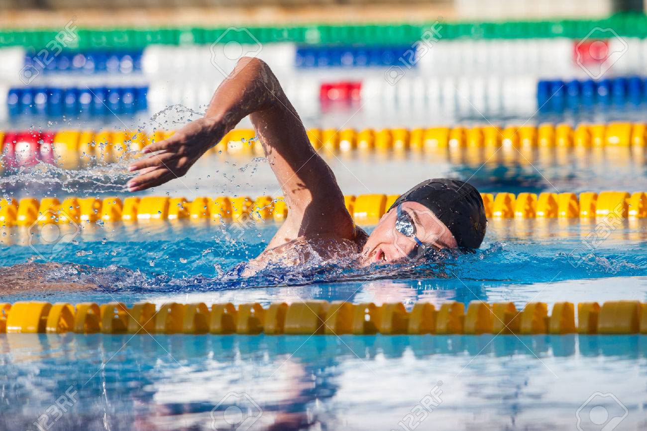 Man swims crawl in the pool, goggles, hat. - 40854885 Man swims crawl in the pool, goggles, hat. - 40854885