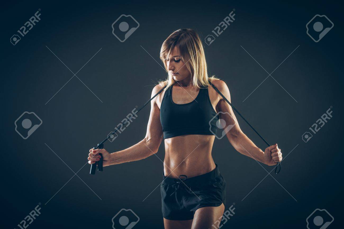 Sport, activity. Cute woman with skipping rope. Muscular woman black background. - 43576345 Sport, activity. Cute woman with skipping rope. Muscular woman black background. - 43576345