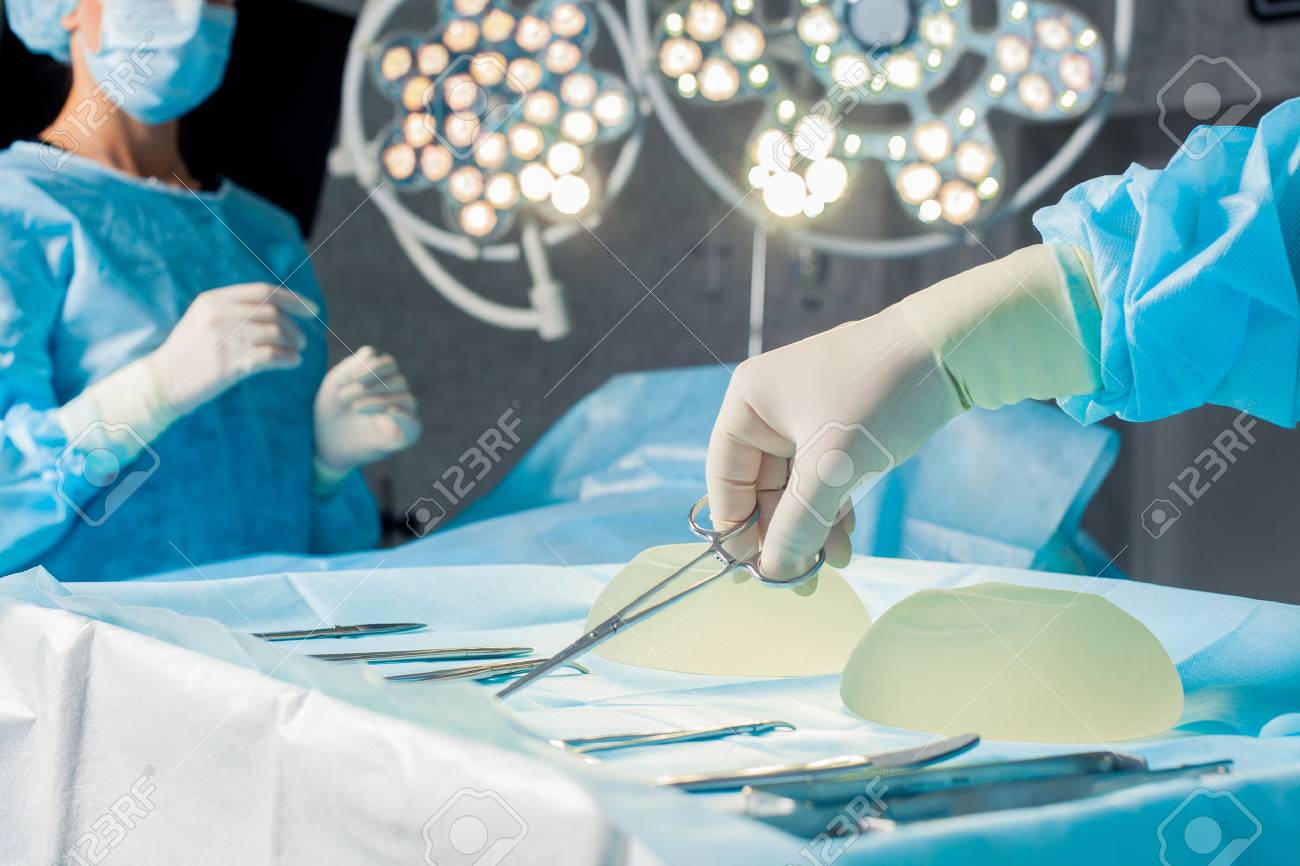 Nurse hand taking surgical instrument for group of surgeons at background - 46516604 Nurse hand taking surgical instrument for group of surgeons at background - 46516604