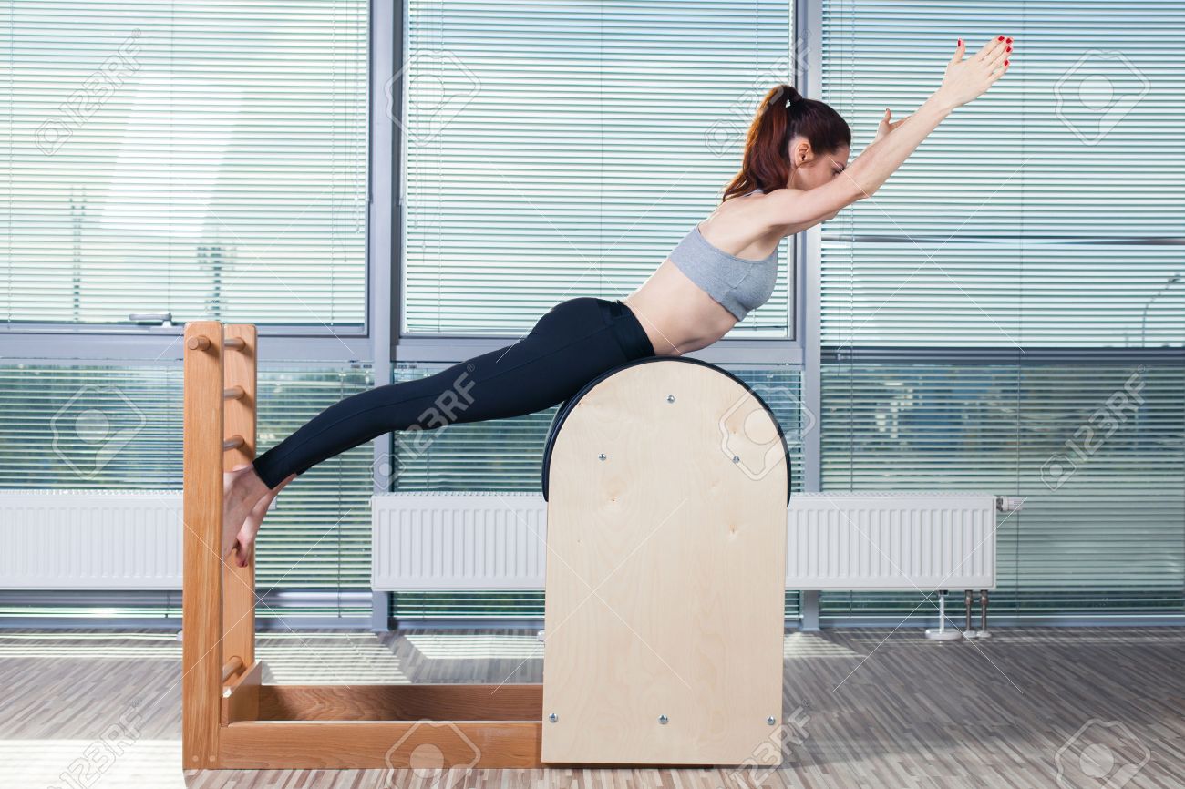 Pilates, fitness, sport, training and people concept - smiling woman doing exercises on ladder barrel. - 47935424 Pilates, fitness, sport, training and people concept - smiling woman doing exercises on ladder barrel. - 47935424