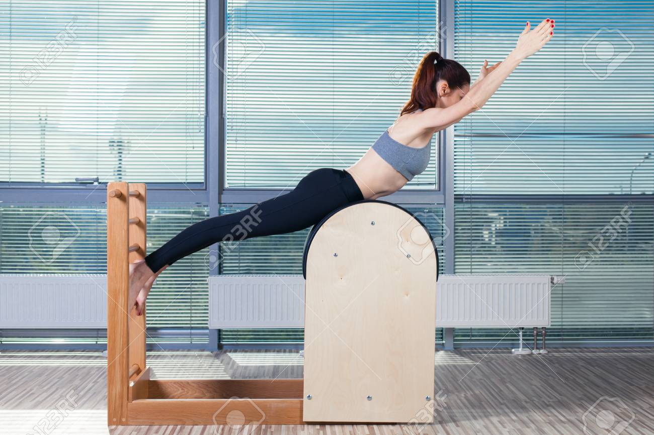 Pilates, fitness, sport, training and people concept - smiling woman doing exercises on ladder barrel. - 48733792 Pilates, fitness, sport, training and people concept - smiling woman doing exercises on ladder barrel. - 48733792