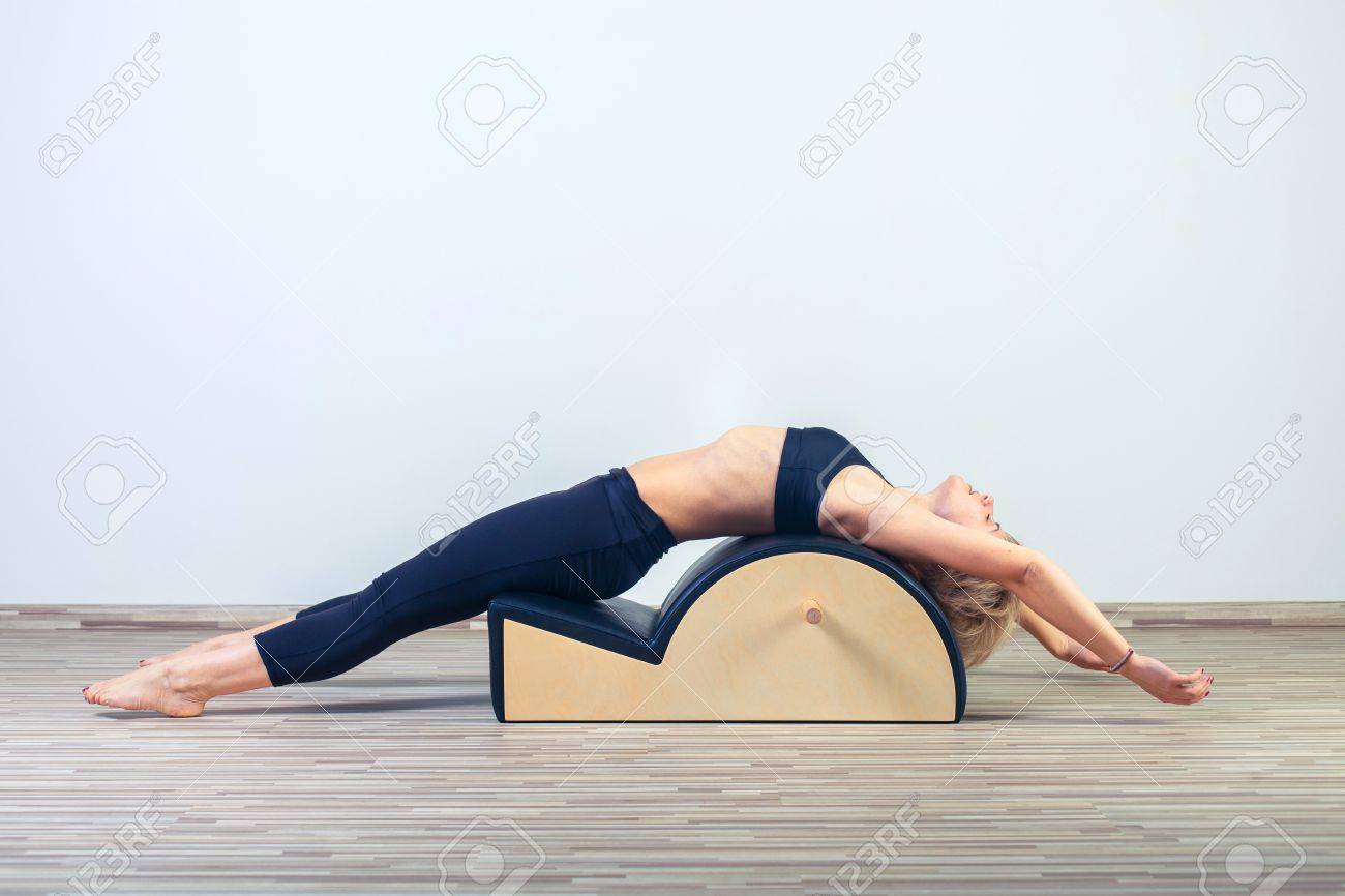 Pilates, fitness, sport, training and people concept - woman doing exercises on small barrel. - 48806382 Pilates, fitness, sport, training and people concept - woman doing exercises on small barrel. - 48806382