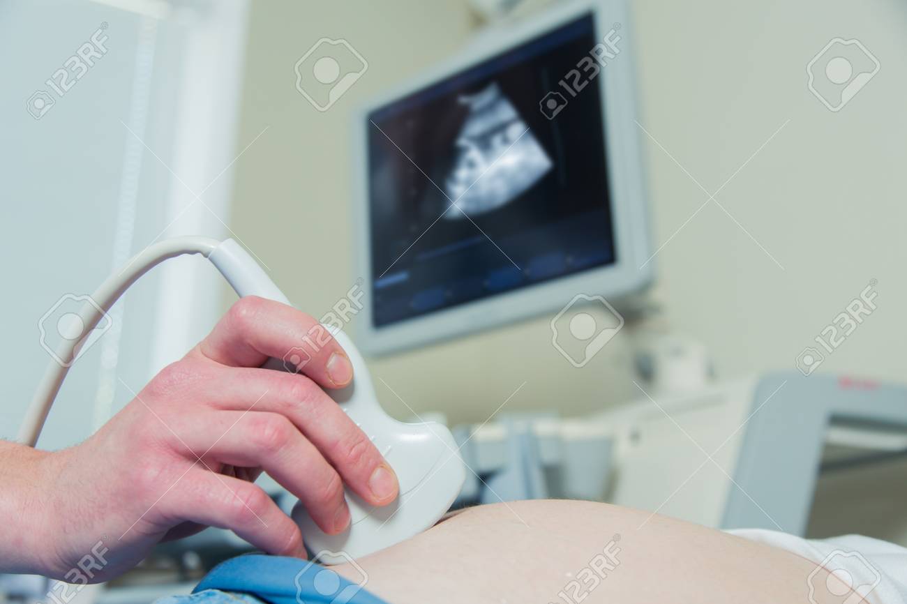 Pregnant woman getting ultrasound from doctor in clinic - 56567297 Pregnant woman getting ultrasound from doctor in clinic - 56567297