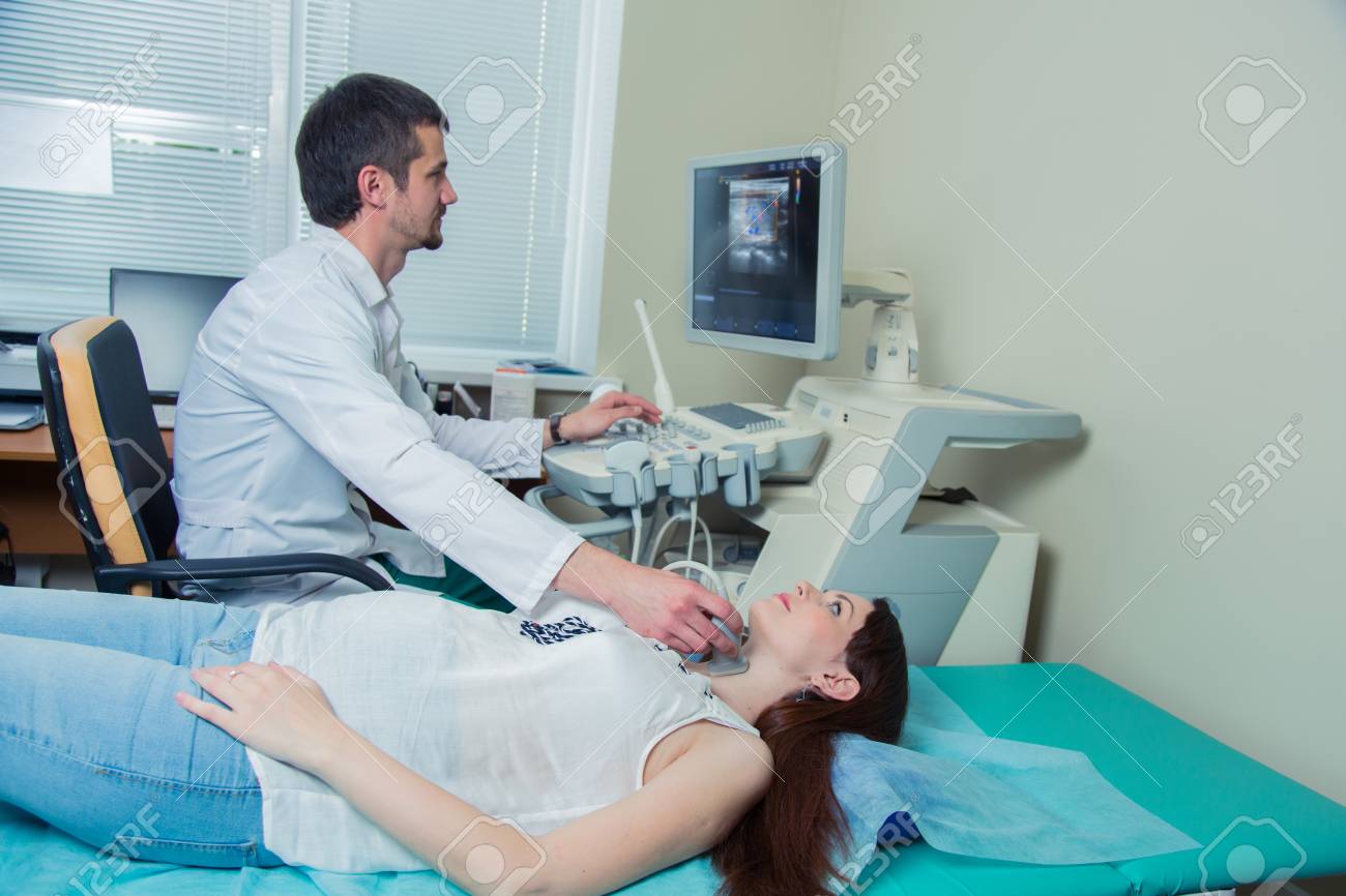 woman getting ultrasound of a thyroid from doctor. - 56567670 woman getting ultrasound of a thyroid from doctor. - 56567670