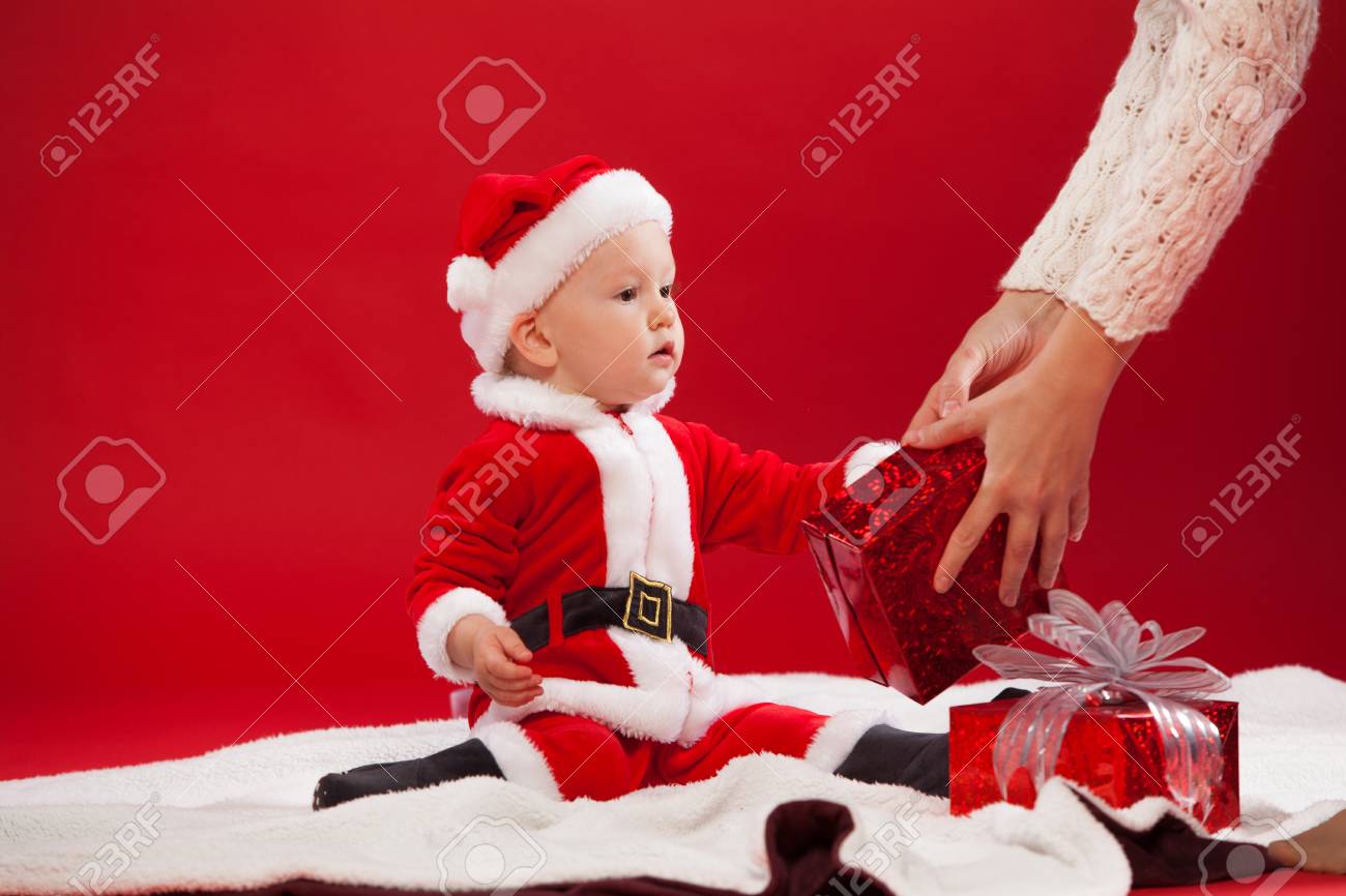 美しい小さな赤ちゃんは クリスマスを祝います 新年の休日 クリスマス衣装の贈り物と携帯電話で赤ちゃん の写真素材 画像素材 Image