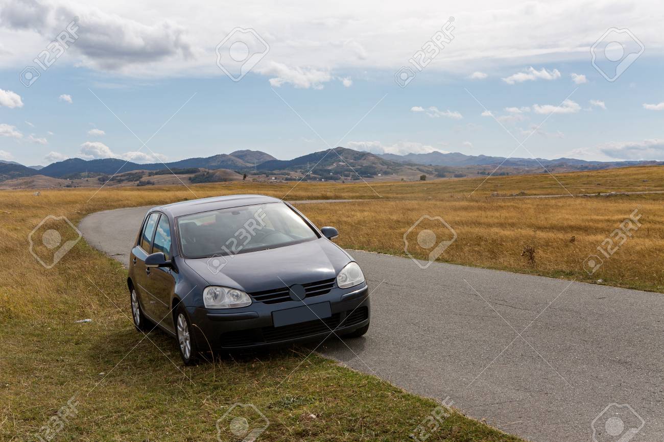 旅行者と車は秋にモンテネグロのザブラクの黄色いフィールドの道端に立っています の写真素材 画像素材 Image