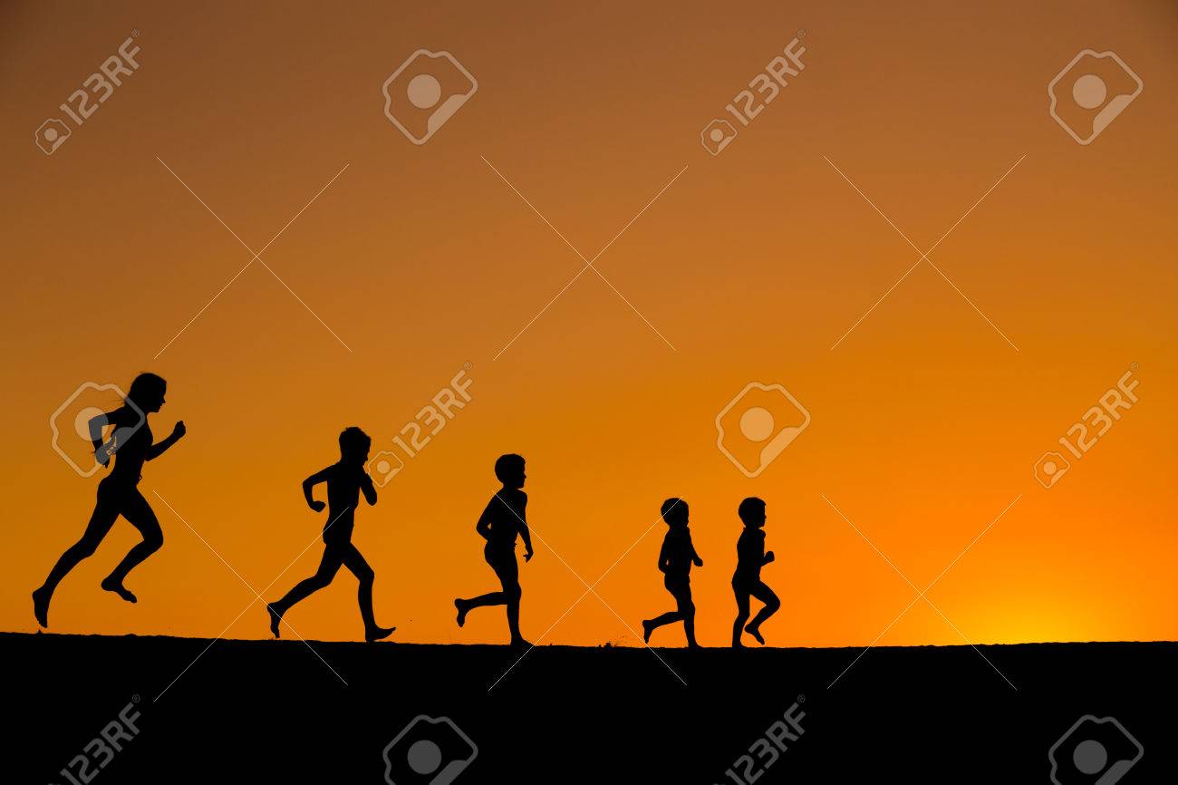 夕日に対してビーチを走る 5 人の子供のシルエット の写真素材 画像素材 Image
