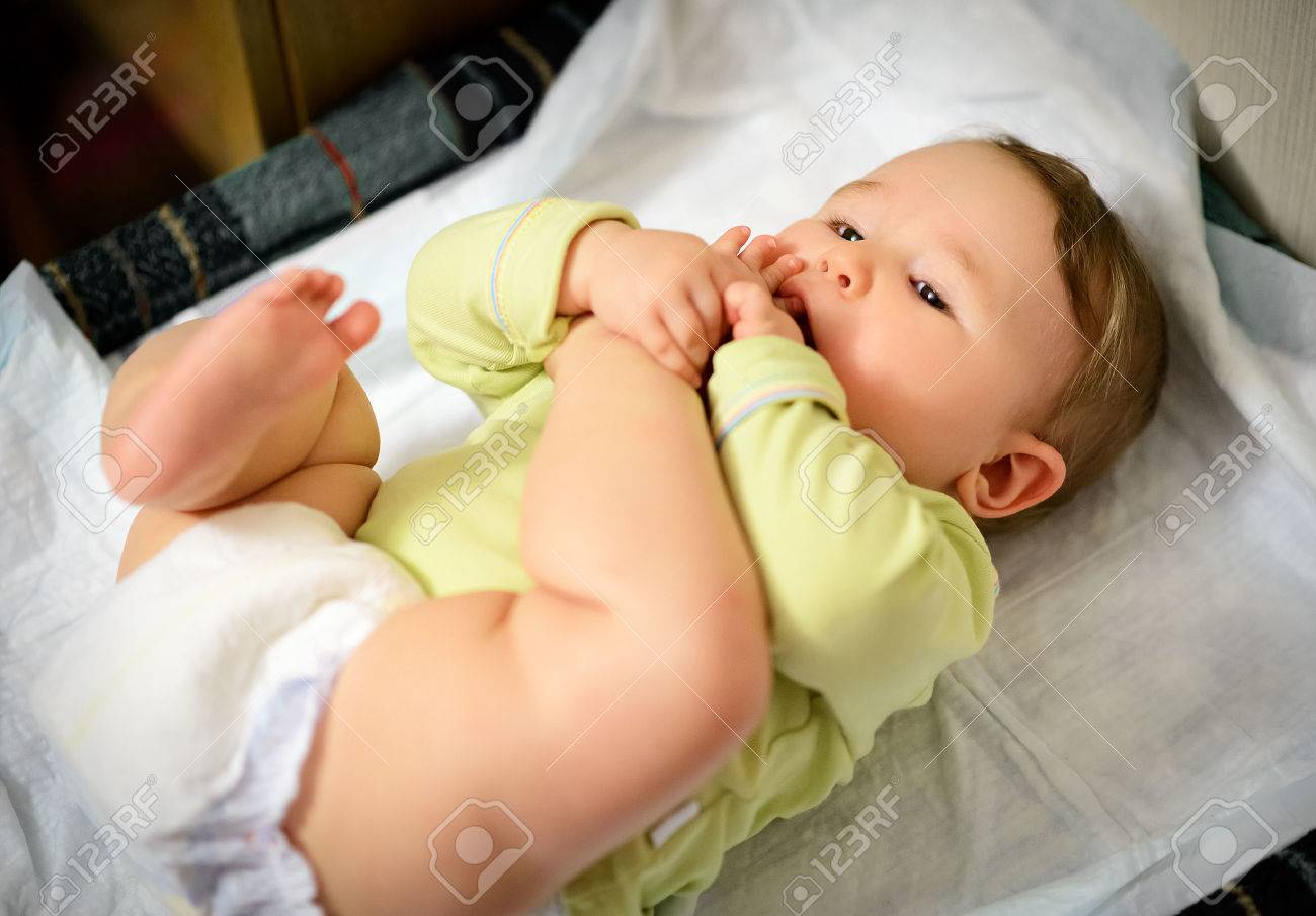 赤ちゃんを抱きしめて彼の足とつま先をしゃぶり の写真素材 画像素材 Image