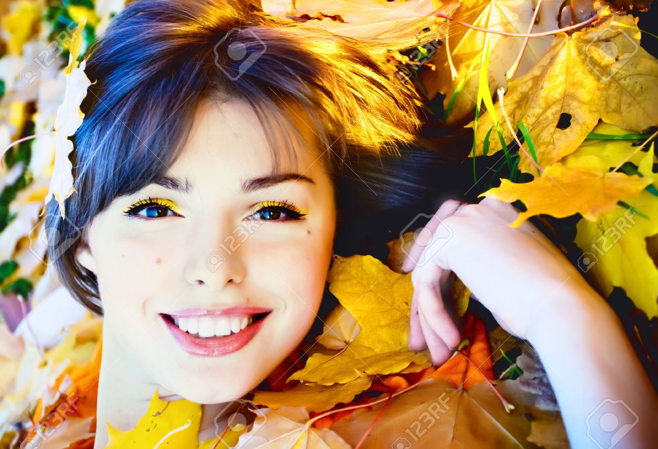Beautiful smiling young woman in autumn leaves - 8171278 Beautiful smiling young woman in autumn leaves - 8171278
