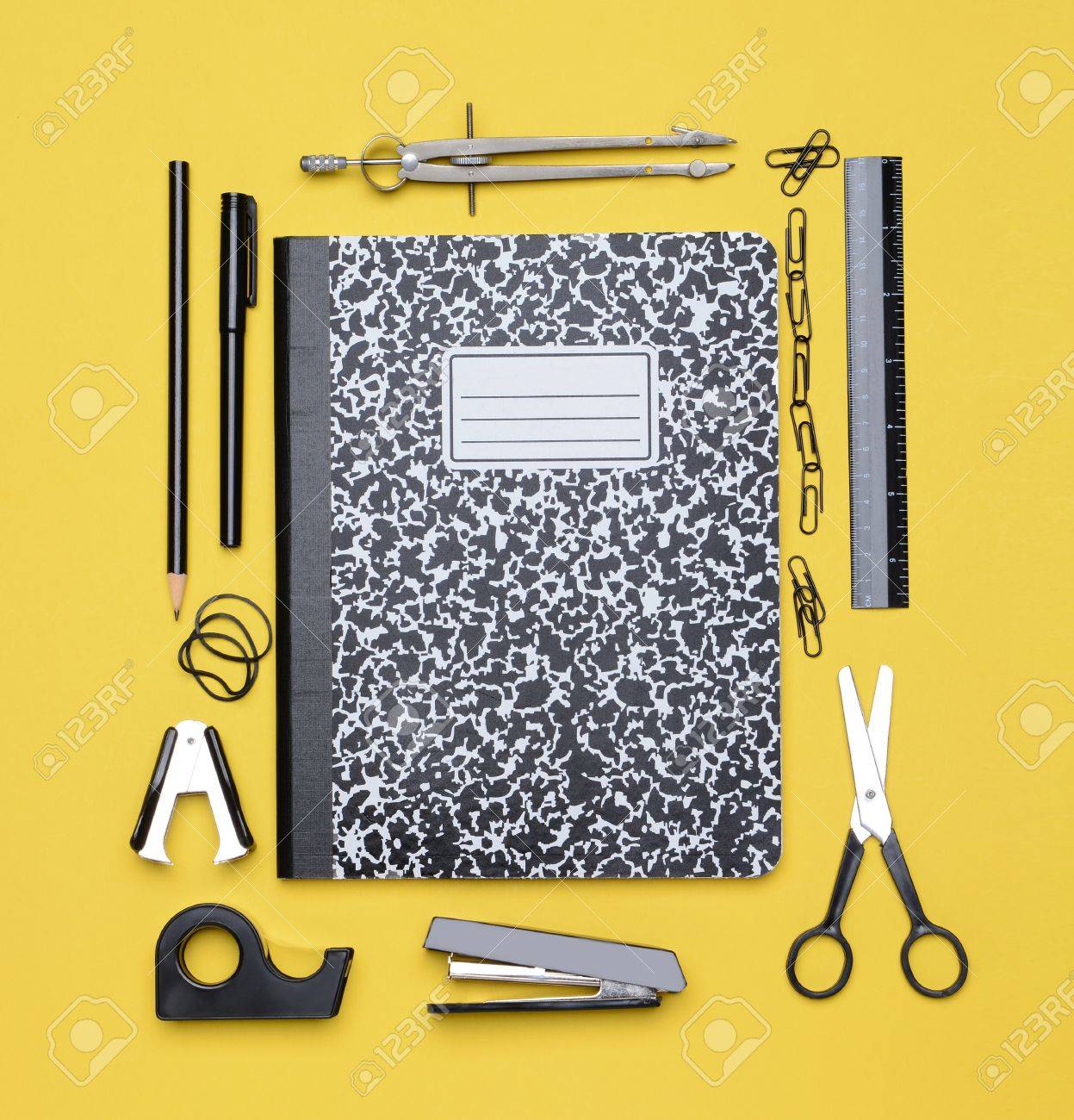 a closed theme book surrounded by school supplies including stock what is theme paper for school