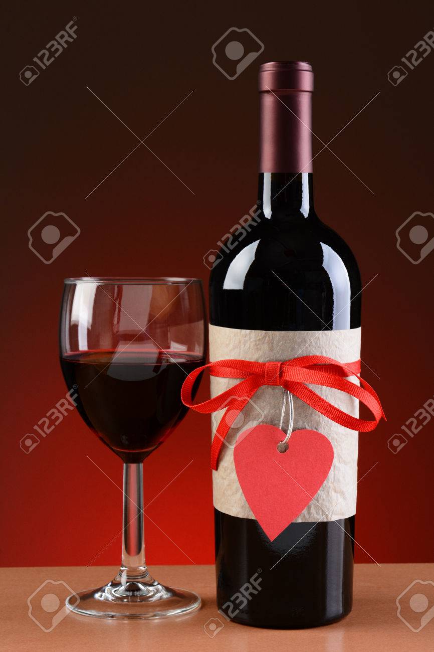 Immagini Stock Primo Piano Di Una Bottiglia Di Vino Decorata Per San Valentino Un Bicchiere Di Vino E Accanto Alla Bottiglia La Bottiglia Ha Un Nastro Rosso E Tag A Forma