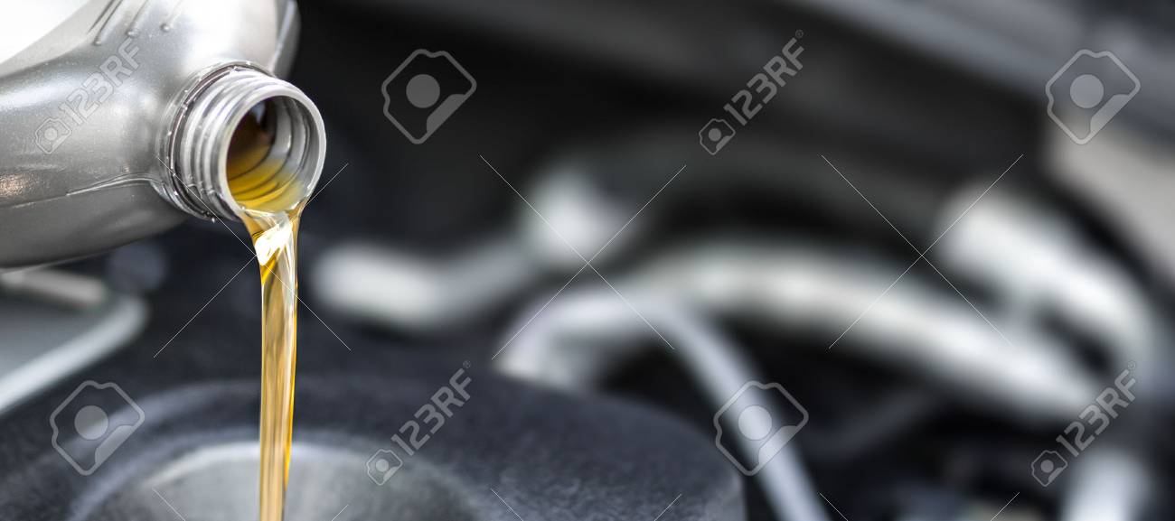 Pouring oil to car engine. Fresh oil poured during an oil change to a car. - 89225205 Pouring oil to car engine. Fresh oil poured during an oil change to a car. - 89225205