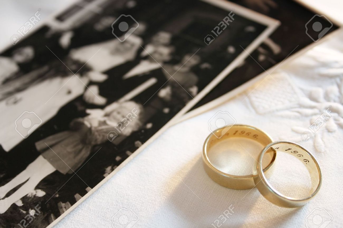 old wedding rings and out of focus black and white photograph of a wedding stock photo - Old Wedding Rings old wedding rings and out of focus black and white photograph of a wedding stock photo - Old Wedding Rings