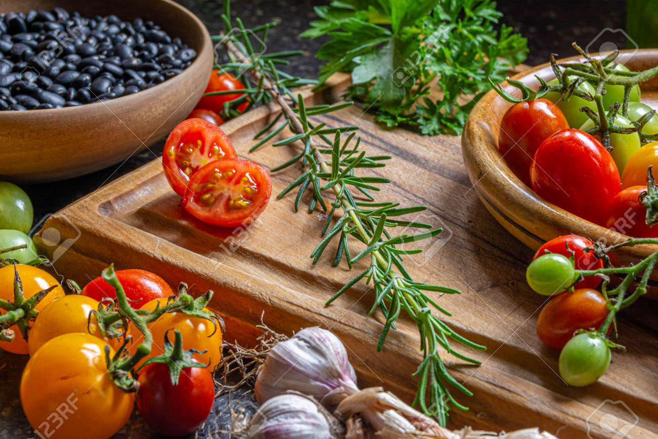 Fresh organic vegetables and ingredients on a wooden cutting board - 166541560 Fresh organic vegetables and ingredients on a wooden cutting board - 166541560