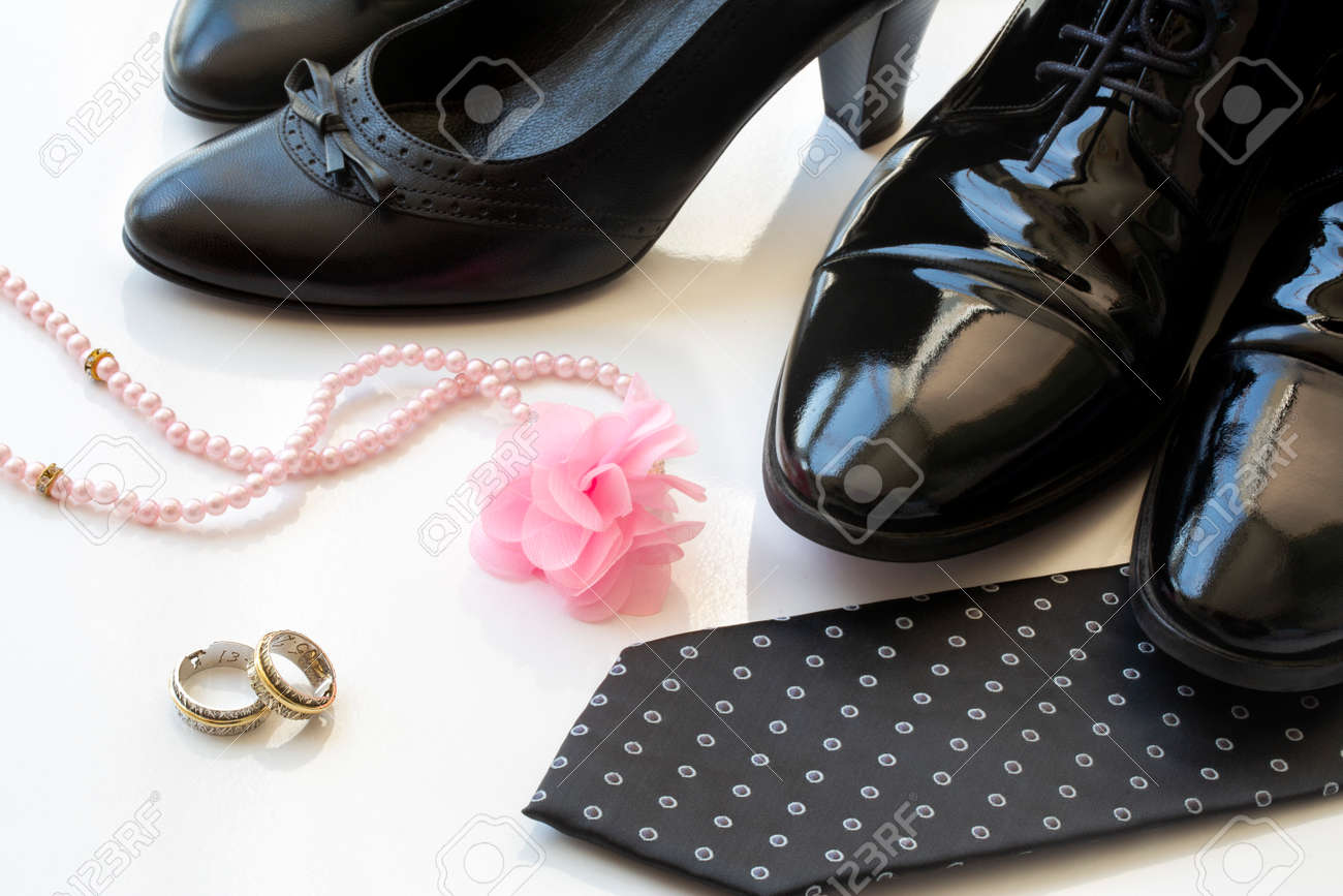 Black man and woman patent leather shoes with wedding rings and pearl necklace on white background. Family law concept. Divorce. Wedding. Honeymoon. - 151106609 Black man and woman patent leather shoes with wedding rings and pearl necklace on white background. Family law concept. Divorce. Wedding. Honeymoon. - 151106609