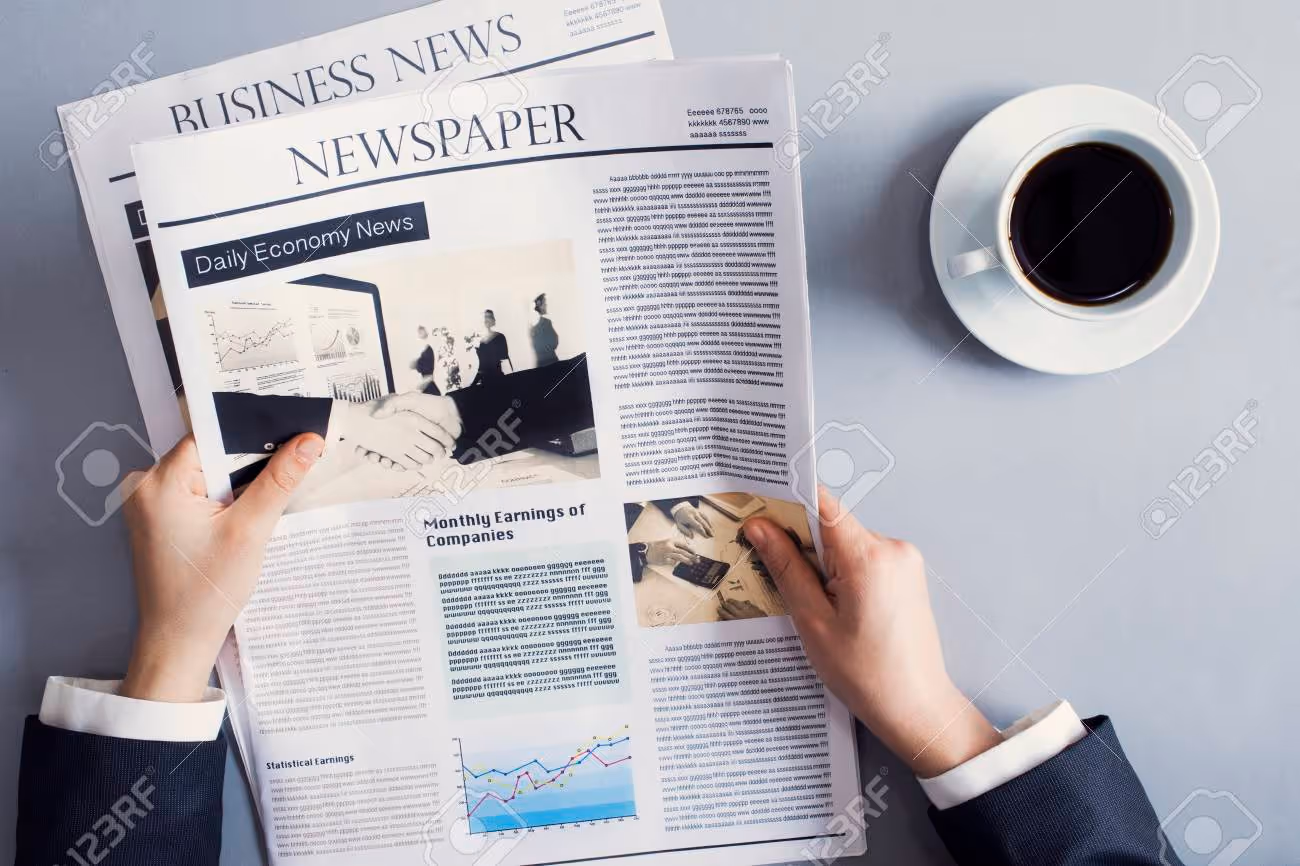 Reading newspaper on desk - 79875086 Reading newspaper on desk - 79875086