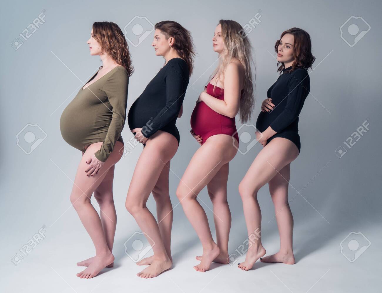 Four beautiful pregnant woman in swimsuit standing one behind the other on a white background. - 140600163 Four beautiful pregnant woman in swimsuit standing one behind the other on a white background. - 140600163